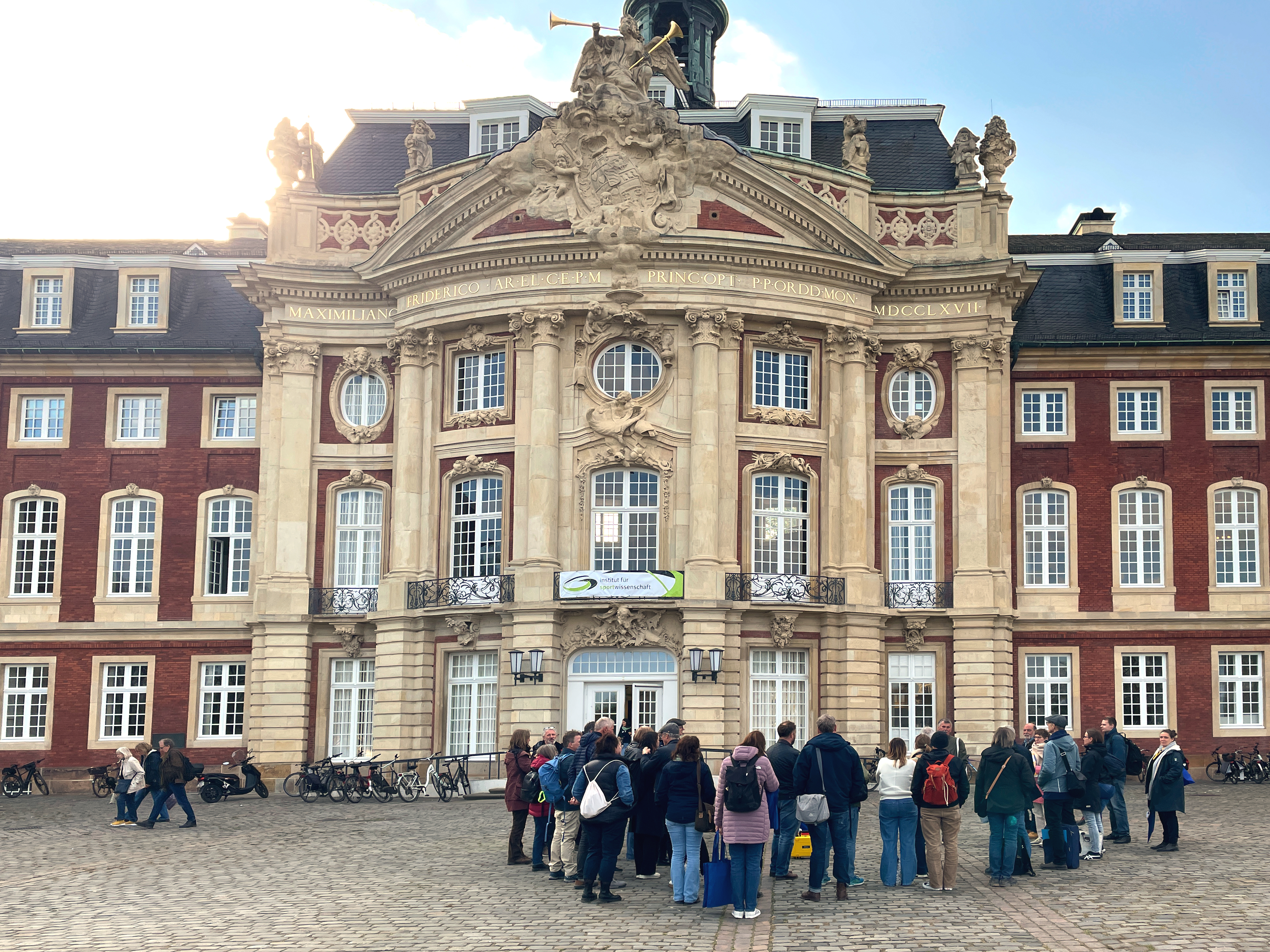 Menschengruppe vor dem Schloss Münster