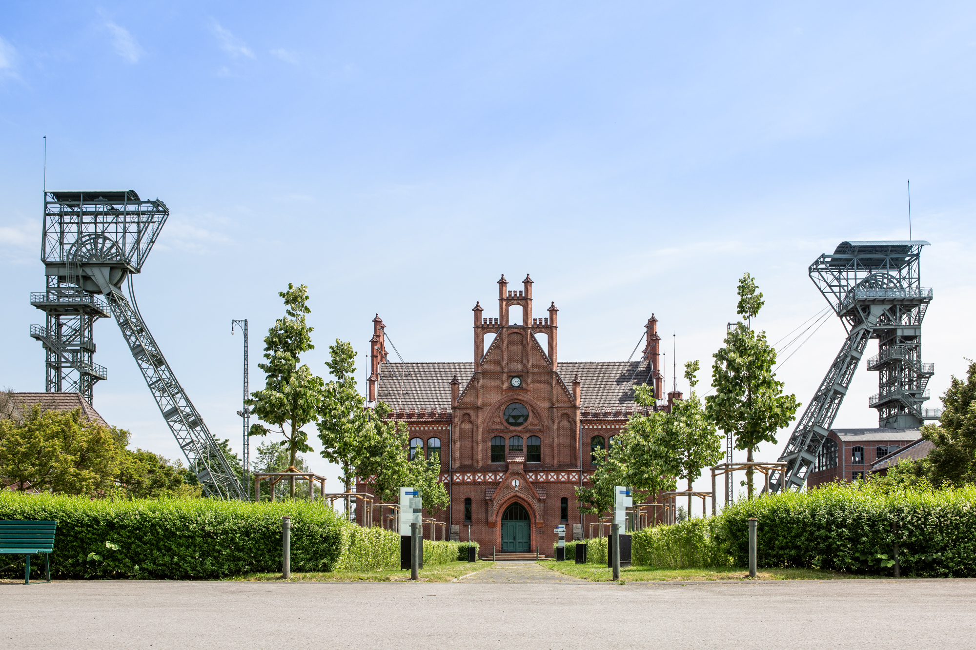 Backsteingebäude mit zwei Fördertürmen auf der linken und rechten Seite.