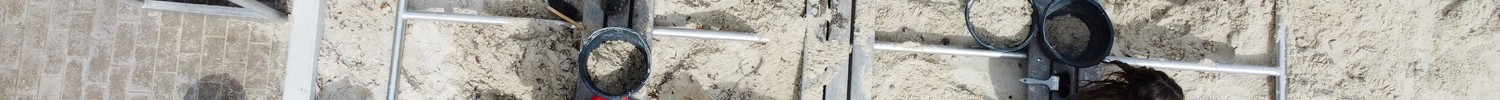 Mehrere Kinder graben an einer Sandfläche mit Schaufeln.