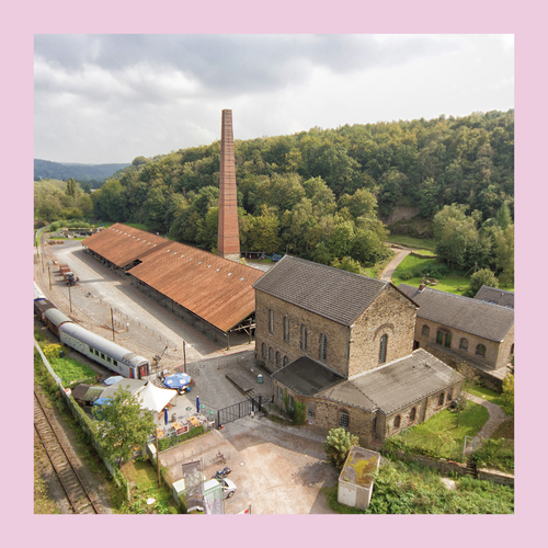 Foto eingefasst in rosa Rahmen. Foto von an der Decke hängender Arbeitskleidung für die Arbeit unter Tage.