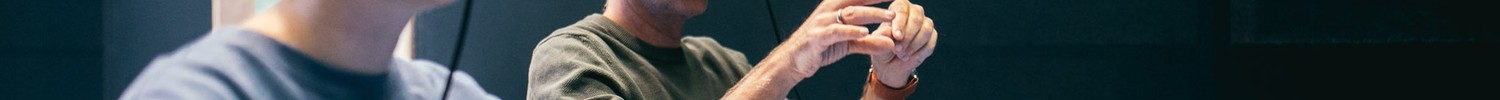 Zwei Personen sitzen an einem Tisch und tragen VR-Brillen.