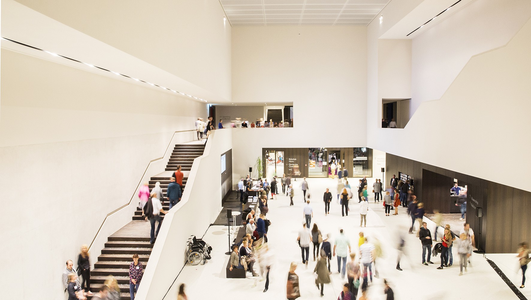 Menschen im hellerleuchteten Museumsfoyer.