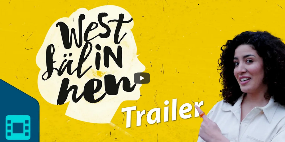 Frau mit lockigem Haar zeigt auf die Schrift 'Westfälinnen Trailer' vor gelbem Hintergrund