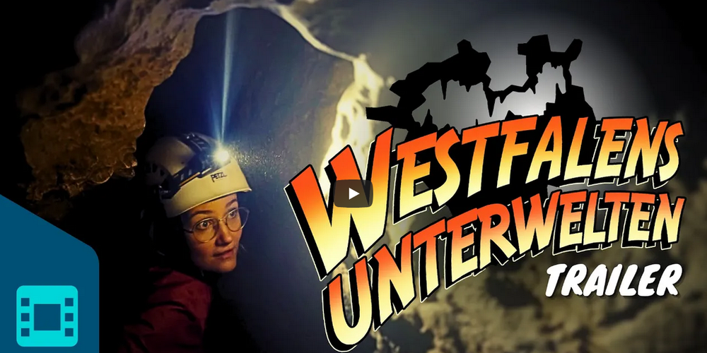 Eine Person mit Schutzhelm in einem unterirdischen Gang, daneben der Schriftzug "Westfalens Unterwelten Trailer"