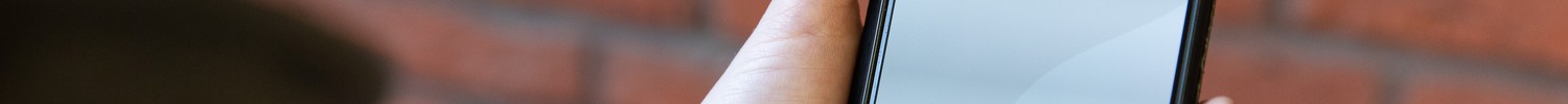 Eine Hand hält ein Smartphone, auf dem Display steht "Palava. Wie spricht NRW?"