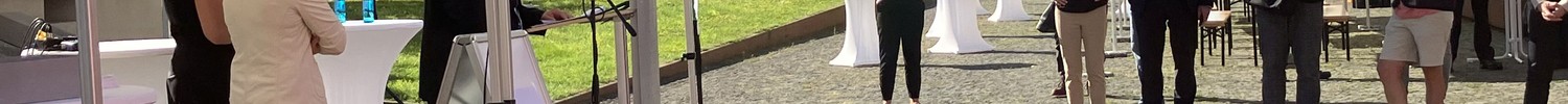Zwei Personen reinigen ein verdrecktes Buch mit Schwamm und Wasserstrahl
