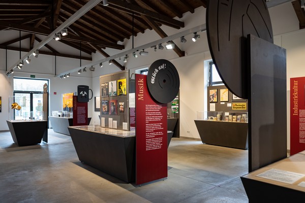 Ausstellungshalle mit Textwänden und Informationsstele