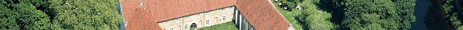 Luftaufnahme vom Kloster, das in einer grünen Landschaft liegt.